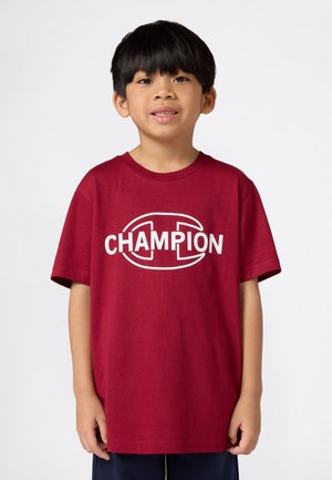 Camiseta de algodón burdeos con mangas cortas y cuello redondo, que presenta un gran logo blanco de "CHAMPION" en el pecho.