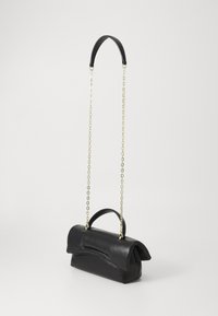 Borsa a mano in pelle nera con design pieghevole, dotata di manico superiore e tracolla in catena dorata. Texture liscia, stile minimalista.