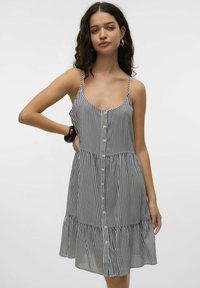 Wzorzysta sukienka na ramiączkach, lekki materiał, guziki z przodu, rozkloszowany dół, granatowo-białe paski, luźny krój i zdobienie w talii.