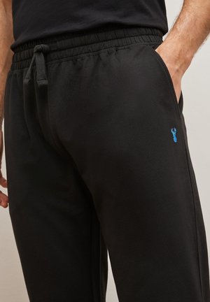 Schwarze Jogginghose aus weichem Stoff, mit einem elastischen Bund und Kordelzug, seitlichen Taschen und einem kleinen blauen Hummer-Logo.