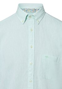 Lichtgroen linnen shirt met button-down kraag, bijpassende knopen, enkele borstzak en bloemenpatroon aan de binnenkant van de kraag. Bevat subtiele boombroderie.
