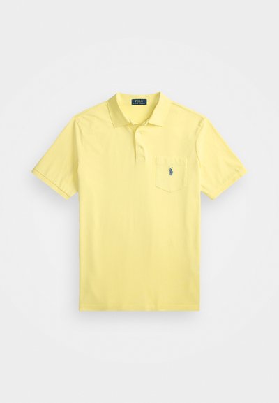 Polo majica s kratkimi rokavi v pastelno rumeni barvi iz bombaža, s placketom na tri gumbe in žepom na levi strani prsnega dela, ki vsebuje majhen moder logo.