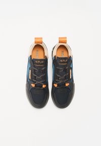 Námořnické a modré tenisky s oranžovými akcenty, texturovaná tkanina, černé podrážky a dvě poutka. Šněrovací design se zesílenou špičkou.