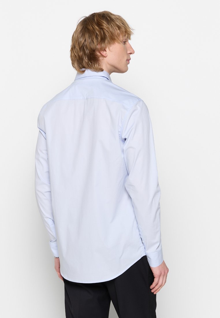 Hellblaues Langarmhemd mit klassischem Kragen, glatter Textur und abgerundetem Saum. Verfügt über Manschetten und ein einzelnes Rückenschlitzdesign.