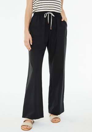 Pantalones de pierna ancha negros con cintura elástica y cordón de ajuste. Presenta dos bolsillos frontales y un ajuste relajado, confeccionados en una tela ligera.