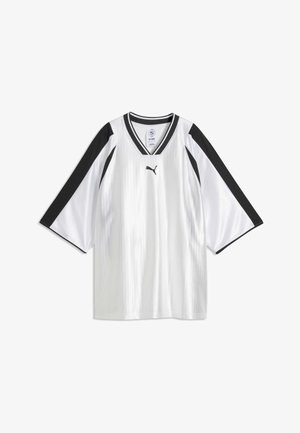 Maillot de sport blanc avec des rayures noires sur les manches, logo Puma noir sur la poitrine et col en V noir et blanc.