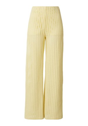 Gelbe weit geschnittene Häkelstrickhose mit hoher Taille und offenem Strickmuster.