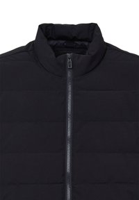 Veste noire matelassée avec col montant et fermeture éclair centrale visible, arborant des coutures horizontales sur un tissu lisse.