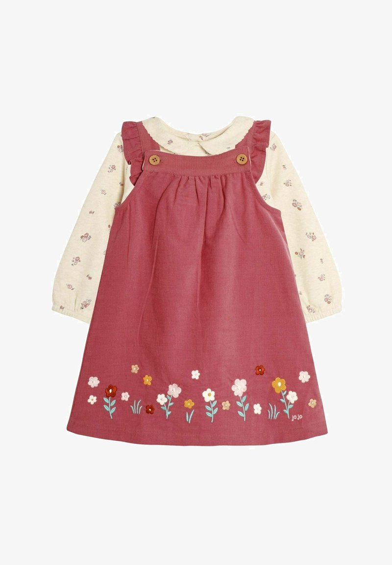 Röd kordverksklänning med volangremmar, två knappar och broderade blommor vid fållen, tillsammans med en krämfärgad blommig långärmad topp.