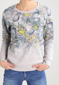 Felpa grigia con un motivo floreale in blu, verde e giallo, con polsini a costine e scollatura rotonda, realizzata in un tessuto morbido.