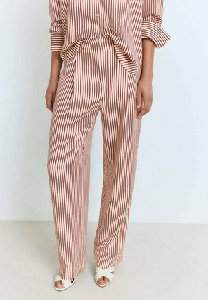Beige pants with narrow rust stripes, loose fit and pleats at the front. Paired with a matching striped shirt. Smooth fabric texture.
