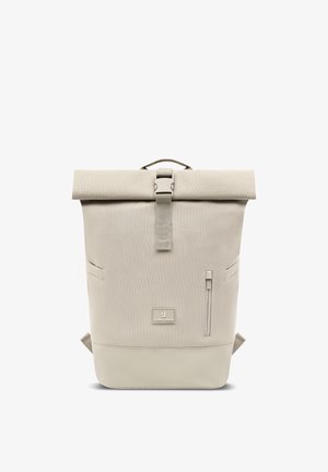 Mochila beige con cierre enrollable, hebilla frontal, correas laterales, bolsillo vertical con cremallera y parche con la marca "Johnny Urban" en el centro delantero.