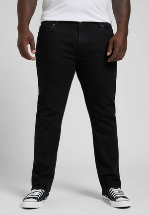 Jeans in denim nero con una vestibilità dritta, cinque tasche e una superficie liscia. Abbinati con sneakers bianche e nere.