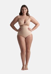 Bañador de dos piezas nude con top de sujetador cruzado y braguita de talle alto. Fabricado con tejido elástico, presenta tirantes delgados ajustables.