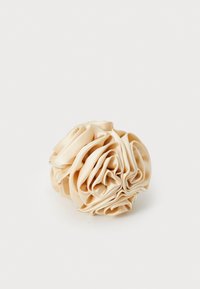Scrunchie de cabelo em cetim bege, em forma circular, texturizado com pregas volumosas, brilho suave, sem peças ou detalhes visíveis, material leve.