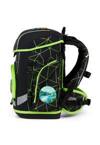 Zaino nero con motivi geometrici verdi, molteplici tasche esterne, accenti riflettenti e una spilla rotonda raffigurante un veicolo.