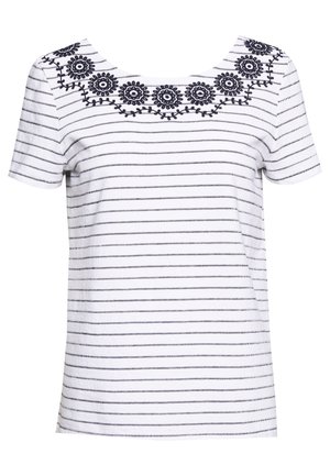 Biała koszula z krótkim rękawem z cienkimi czarnymi poziomymi paskami oraz czarnym haftowanym kwiatowym wzorem wzdłuż szerokiego, głębokiego dekoltu.