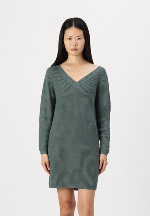Robe en tricot verte avec un décolleté en V et des manches longues, présentant un motif texturé et une silhouette ajustée qui se termine au-dessus du genou.