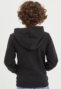 Felpa nera con cappuccio, orlo e polsini a coste, caratterizzata da un ampio cappuccio piegato e un design semplice sul retro.