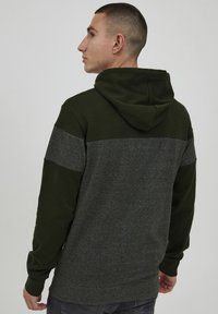 Capuchon sweatshirt met donkergroene stof en een heather grijze horizontale streep over de rug en textuurmouwen.