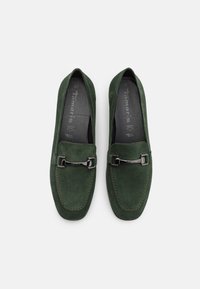 Gröna mocka loafers med en silverspänne som accent. Har en rund tå, sömnadsdetaljer och en vadderad sula. Storlek 37.