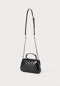 Black quilted handbag with a structured shape, featuring a detachable chain strap and a top handle. Smooth leather texture with gold accents.