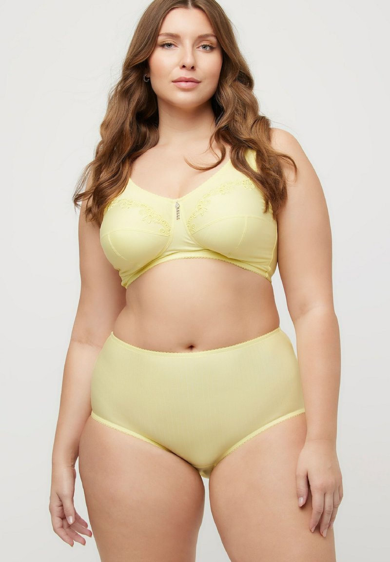 Conjunto de sujetador amarillo y bragas de tiro alto, con bordado floral y un pequeño detalle de joya en el centro, hecho de una tela suave y elástica.