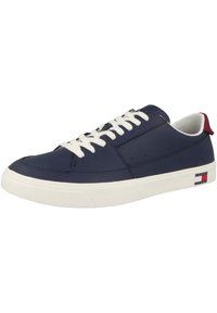 Zapatillas sintéticas de color azul marino con cordones blancos, cuello acolchado y suela de goma texturizada. Presenta un acento del logo de la marca en rojo, blanco y azul.