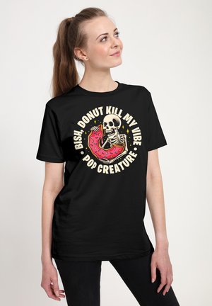 Sort bomulds-t-shirt med et grafisk motiv af et skelet, der spiser en lyserød glasur-donut, med hvid tekst, der buer rundt om designet.