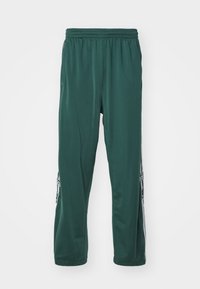 Dark green athletic pants made of smooth, lightweight material, featuring an elastic waistband and white side stripes with branding detail.