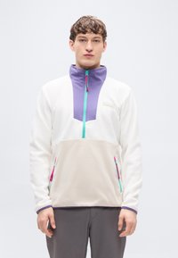 Λευκό φλις πουλόβερ με μοβ γιακά, τυρκουάζ φερμουάρ και μπεζ εμπρόσθιο πάνελ. Διαθέτει δύο πλευρικές τσέπες με φερμουάρ και ροζ λεπτομέρειες.