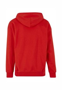 Felpa rossa con cappuccio, tasca a marsupio, cappuccio regolabile con cordino e polsini a coste. Realizzata in morbido tessuto testurizzato con una vestibilità rilassata.