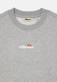 Sudadera de cuello redondo gris claro con el logo blanco de "ellesse" y un emblema semicircular en rojo-naranja centrado debajo del escote.