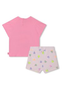 T-shirt rosa a maniche corte con chiusura a bottoni sul retro e pantaloni corti grigi con un motivo a cuori multicolore. Materiale in cotone morbido.