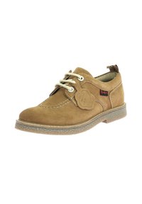 Zapatos de ante marrón con cordones y punta redonda, con costuras blancas y suela de goma. Presentan una etiqueta decorativa en el lateral.
