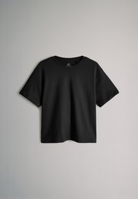 T-shirt noir à manches courtes avec col rond et ourlet droit, présenté sur un fond uni gris clair.
