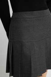 Grijze geplooide rok van gestructureerde stof met subtiele krijtstreepjes, voorzien van een getailleerde taille en een gelaagd ontwerp.