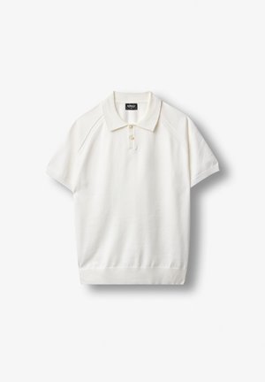Polo blanc à manches courtes avec manches et ourlet côtelés, patte à deux boutons et col sur un fond uni.