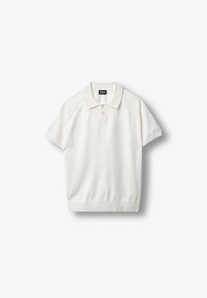Polo blanc à manches courtes avec manches et ourlet côtelés, patte à deux boutons et col sur un fond uni.