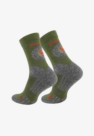 Grüne Crew-Socken mit kontrastierendem dunkelgrauem Fersen- und Zehenbereich. Enthält ein rotes Logo und ein strukturiertes Design für zusätzlichen Halt.