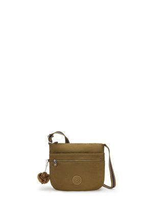 Brun crossbody taske med lynlåslomme foran, stribet skulderrem og lille pelsdækket abe-nøglering fastgjort på hvid baggrund.