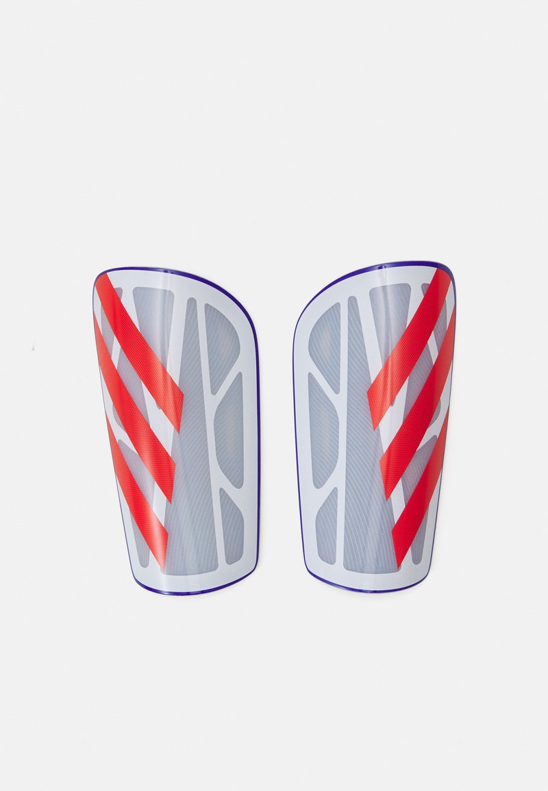 Espinilleras protectoras de plástico transparente con superficies texturizadas, con rayas diagonales rojas y acentos morados a lo largo de los bordes.