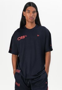 Navy mesh athletic t-shirt with red accents, featuring a crew neck, short sleeves, and bold logos on the front and sleeve.