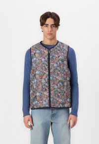 Floral-patterned vest with a zip front, featuring various shades of blue, pink, and orange flowers on a dark background. Textured fabric.