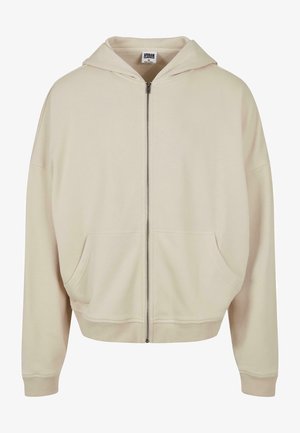 Sudadera beige con cremallera, capucha, bolsillos frontales, puños y dobladillo acanalados. Hecha de un material suave con una textura lisa.
