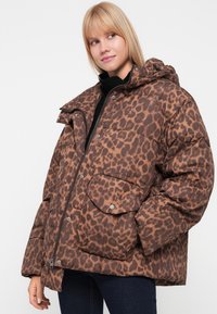 Hnědá leopardí bunda s podšívkou a kapucí, která má kapsy na patentky a zipový přední díl. Texturovaná tkanina s lesklým povrchem.