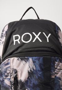Mochila negra y estampada con el logo "ROXY", con una mezcla de diseños abstractos en azul y rosa y un bolsillo frontal con cremallera.