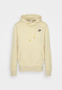 Cream-colored Nike hoodie made from soft fabric. Features a kangaroo pocket, drawstrings with tassels, and a black logo on the chest.