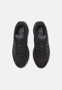 Černé sportovní boty s texturovaným síťovaným svrškem a šněrováním. Mají polstrovanou podrážku a logo na jazyku a boku.