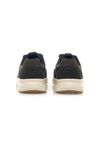 Baskets bleu marine et grises avec un upper texturé, une semelle rembourrée et une boucle à l'arrière ; elles présentent une finition lisse et un design minimaliste.